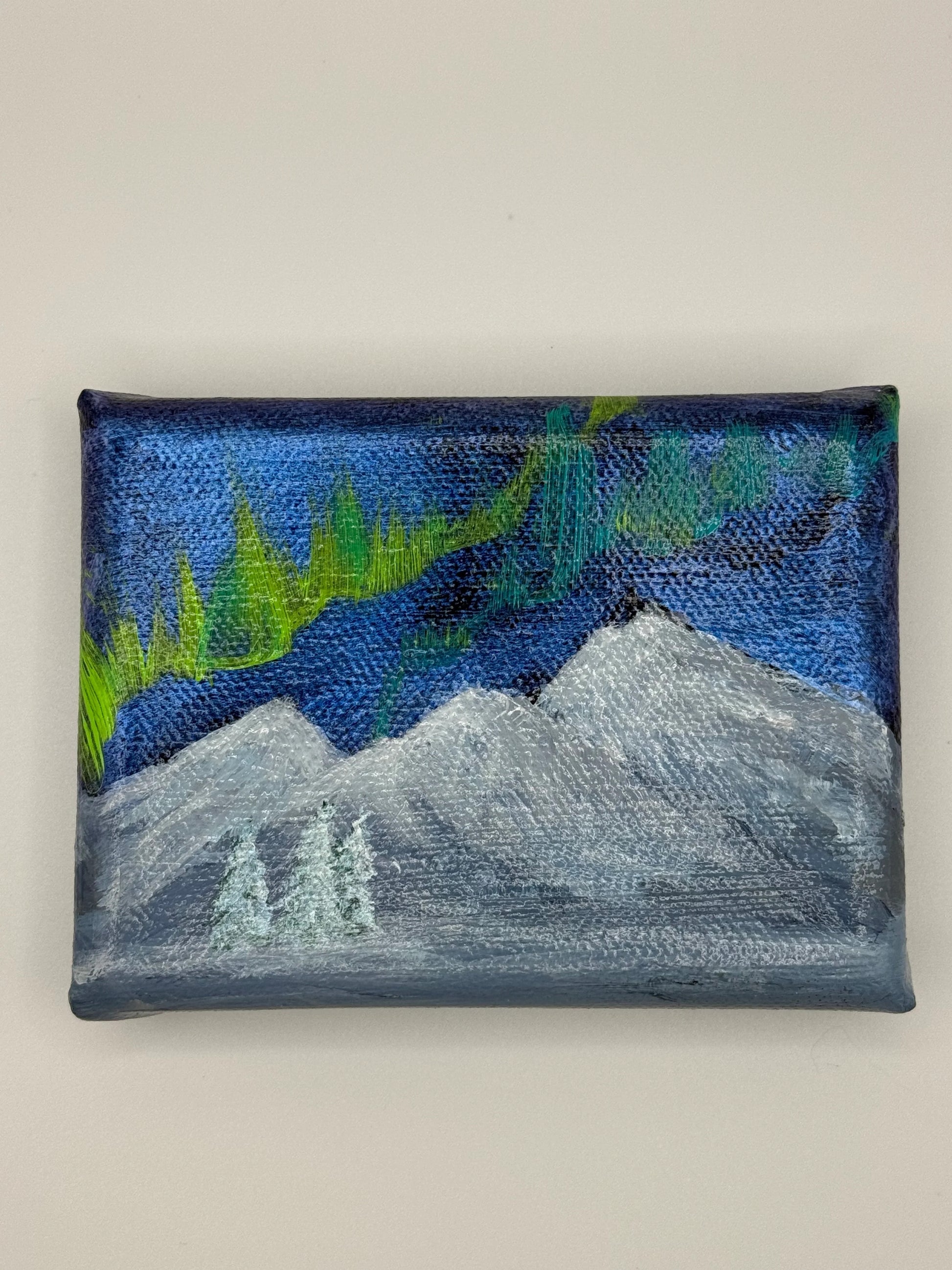 Front of magnet with auroras over mountains