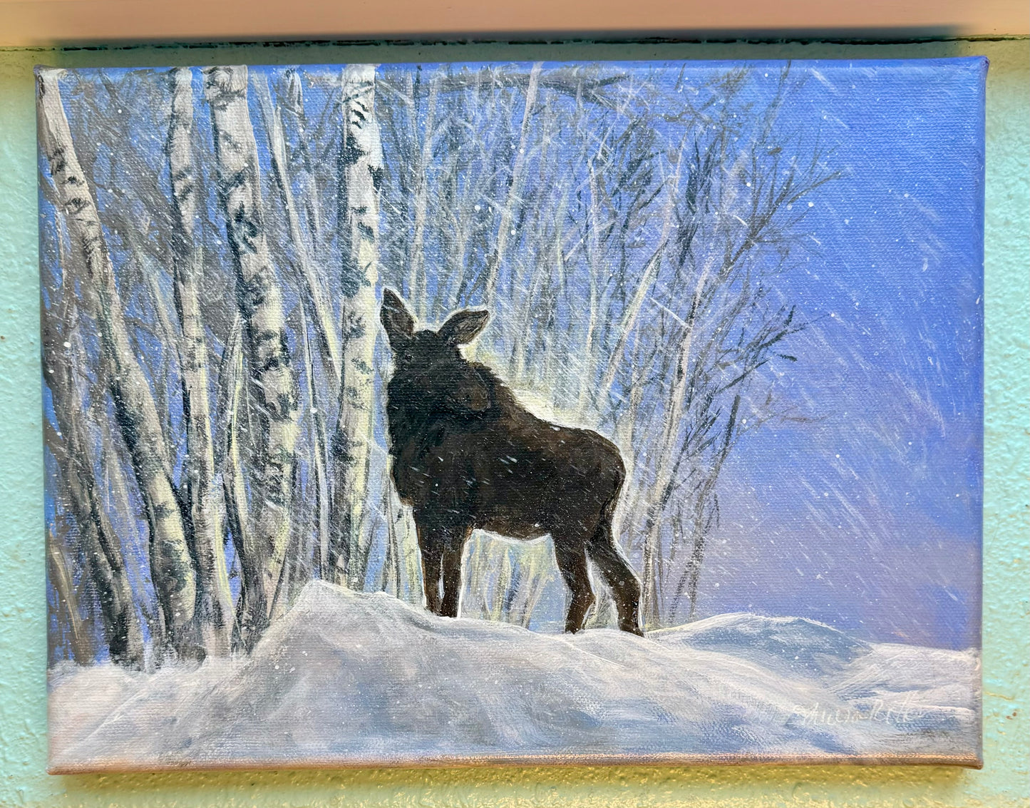 Painting of moose on large snowpile foraging for food on higher branches