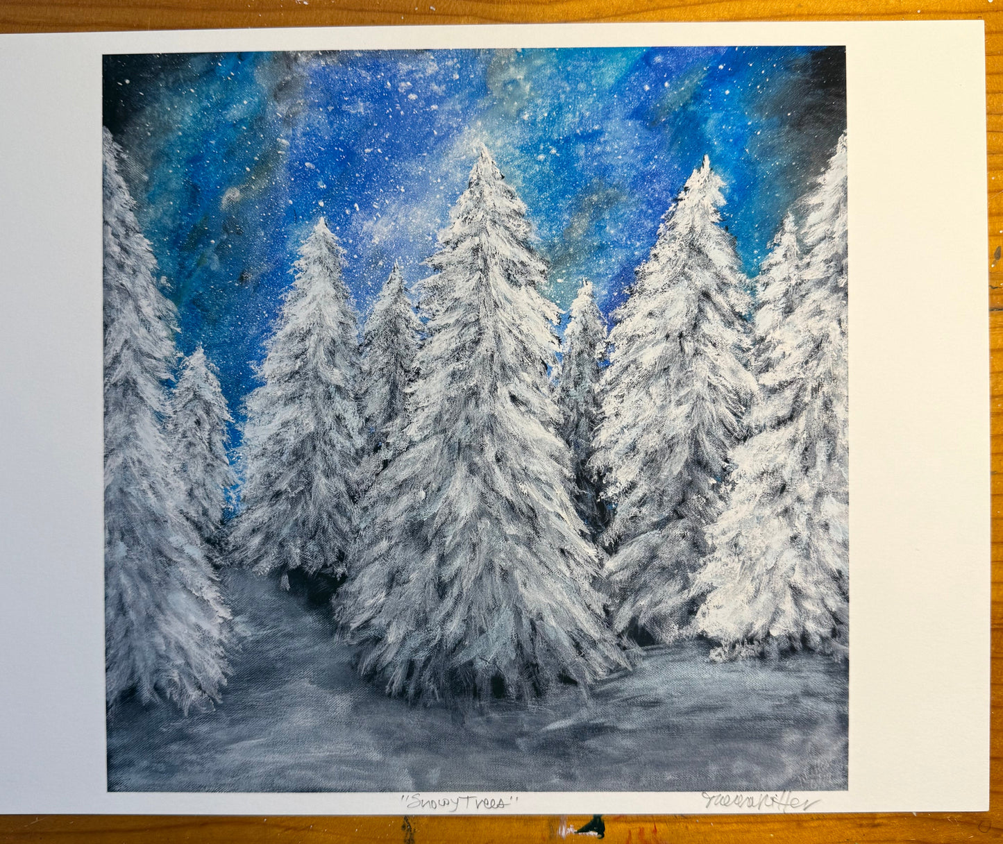 Snowy trees underneath an aurora filled sky