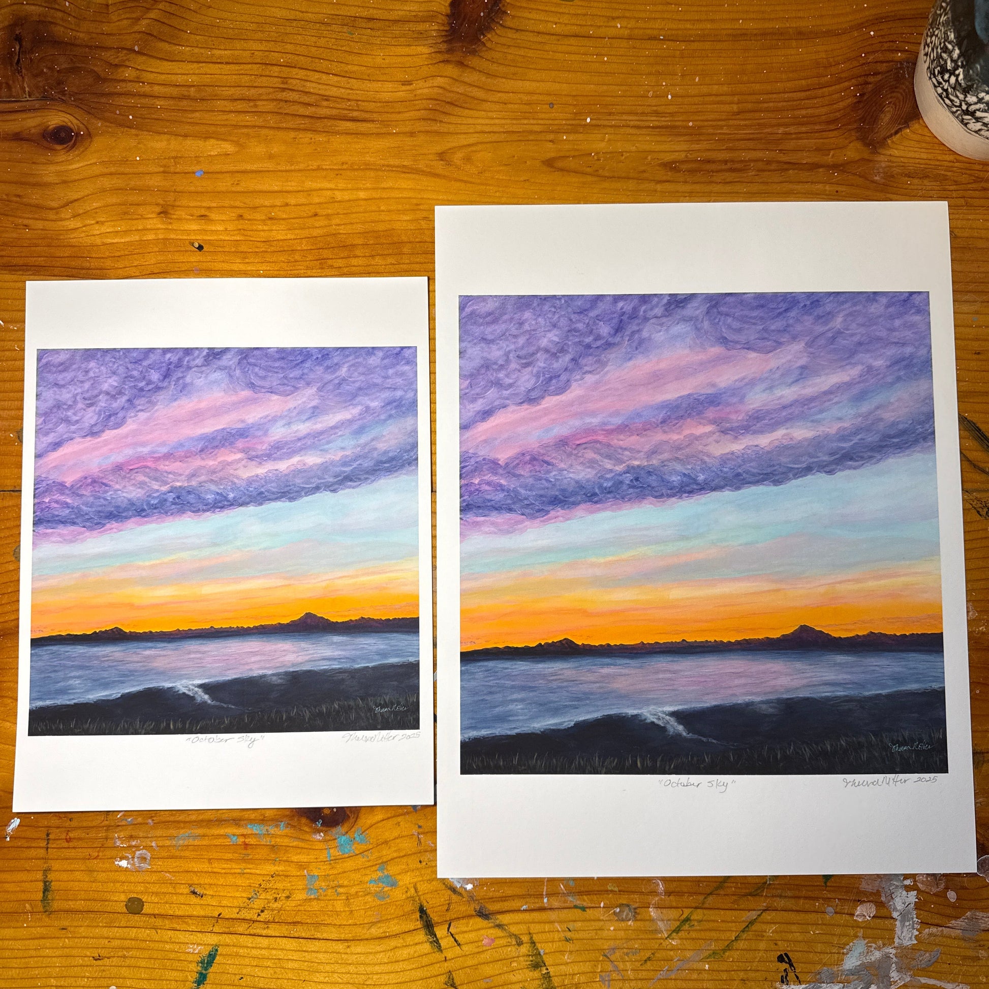Two art prints painted in acrylics of Mount Redoubt as viewed from across the inlet in Kenai, alaska