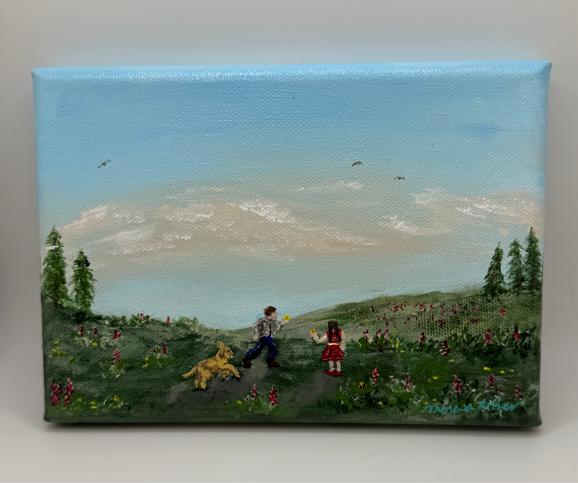 A 5" x 7" original acrylic painting on canvas depicting two children playing ball with a golden retriever puppy in a field of fireweed.